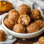 Pumpkin Protein Balls on a plate with oats and pumpkin